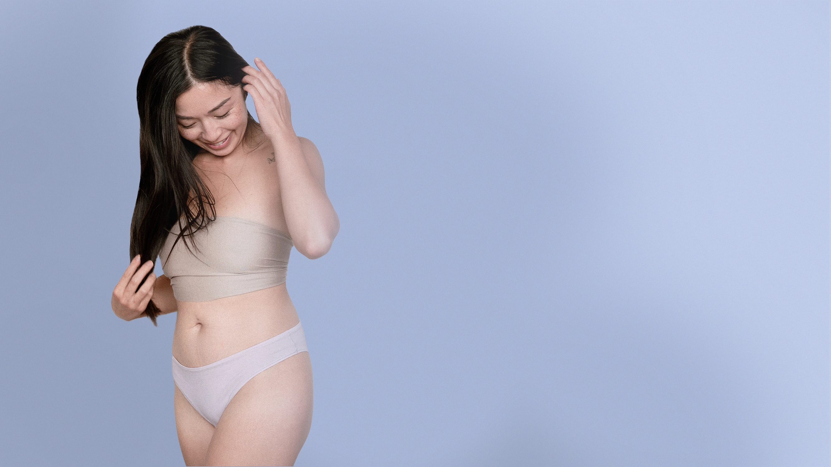 Woman wearing Kiseau natural organic cotton and seaweed blend underwear against a light blue background in a hero shot