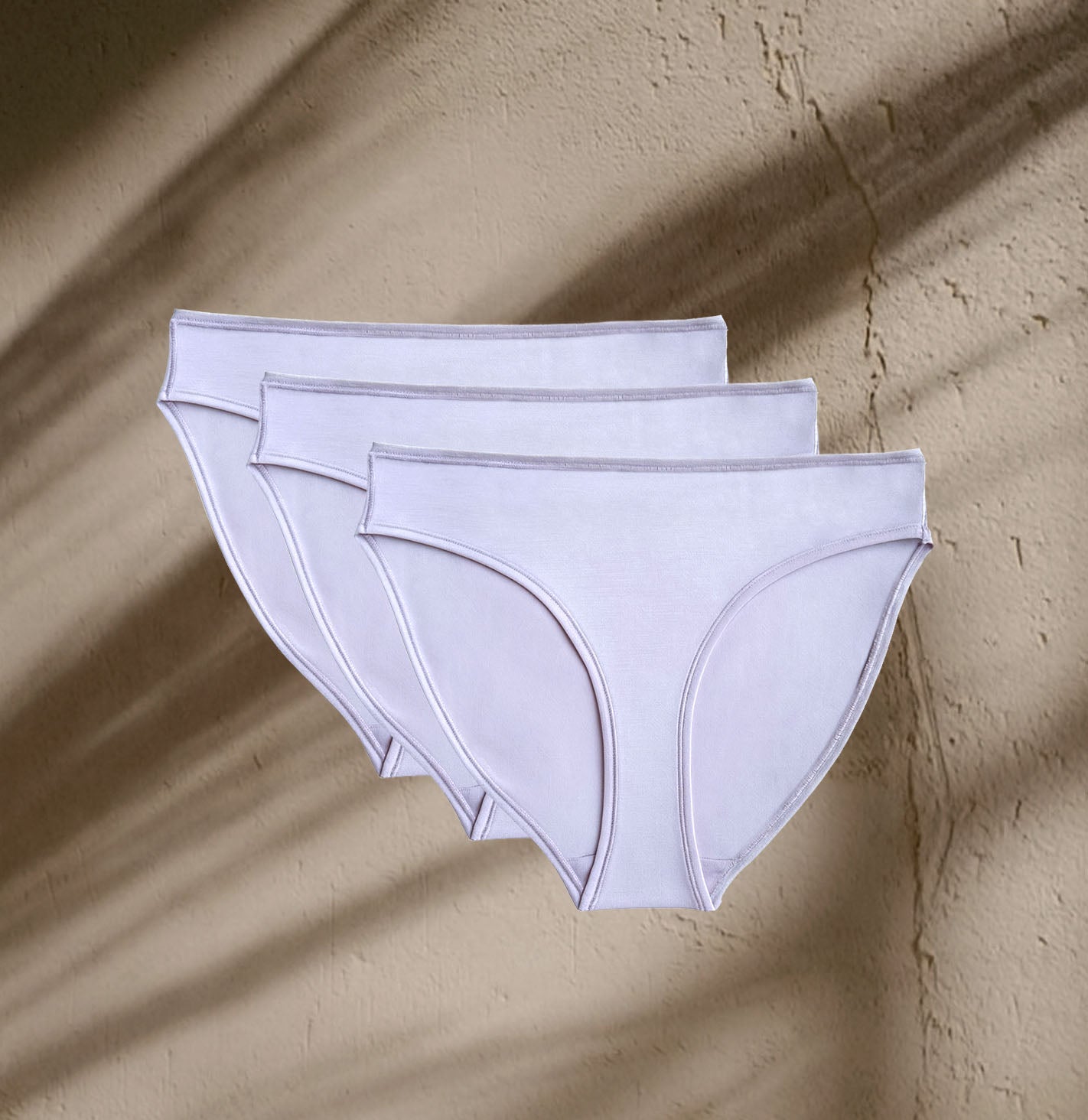 Three pairs of Kiseau Organic Cotton Bikini Underwear in soft neutral tone, sustainable and breathable natural fabric.