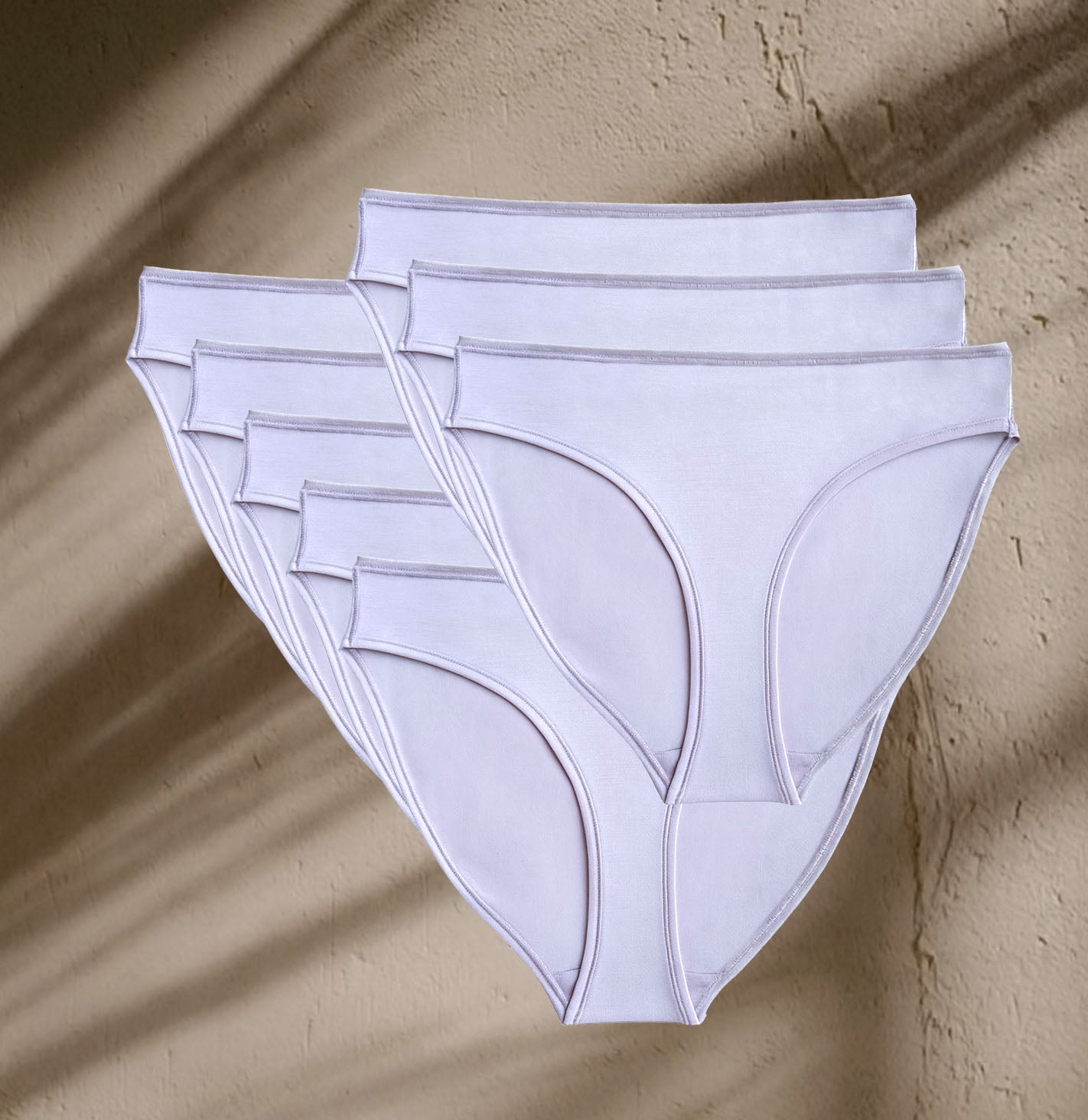 Seven pairs of Kiseau Organic Cotton Bikini Underwear in rose blush tone, sustainable, toxin-free, and plastic-free design.