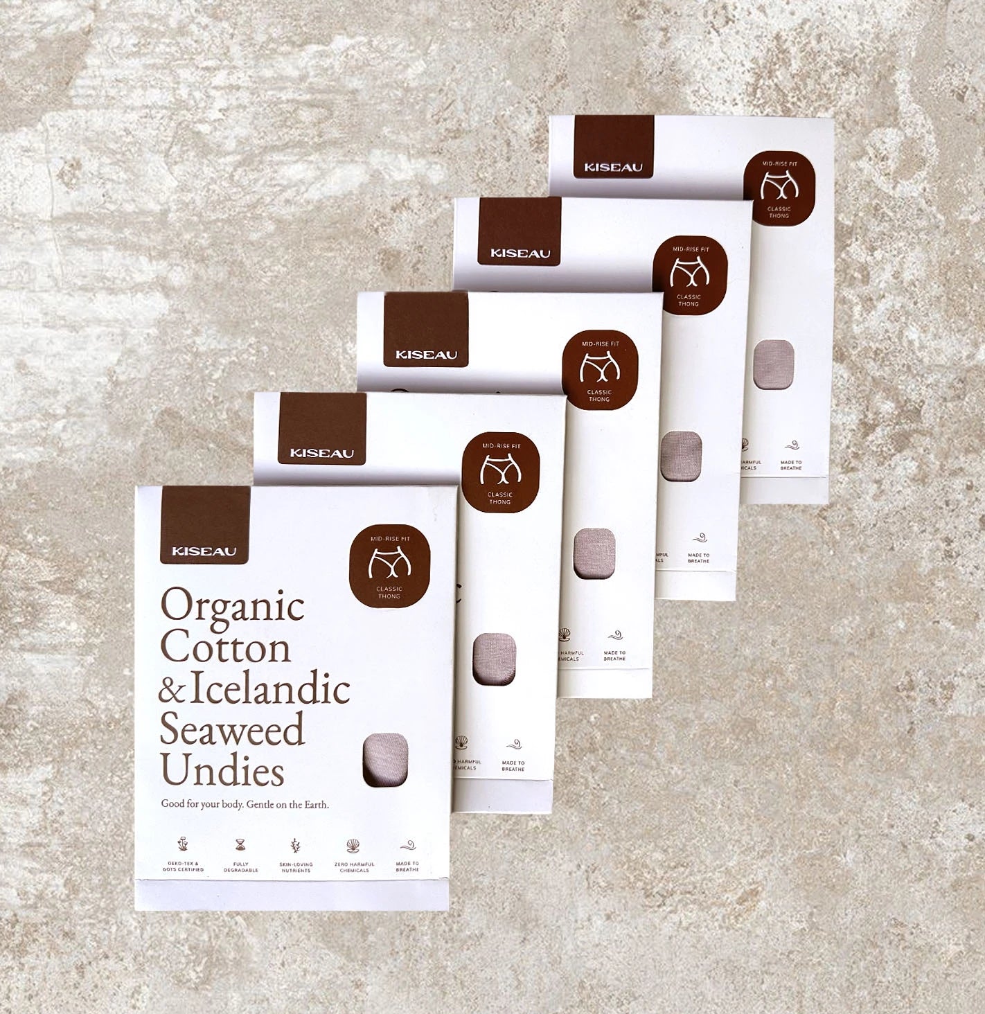 Five Kiseau Organic Cotton & Icelandic Seaweed underwear boxes arranged on stone background, sustainable and eco-friendly packaging.