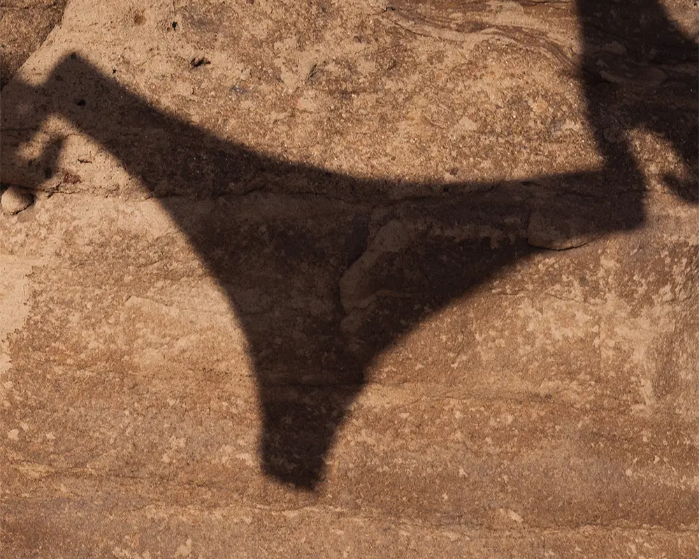 Shadow of a a pair of panties on a textured stone surface