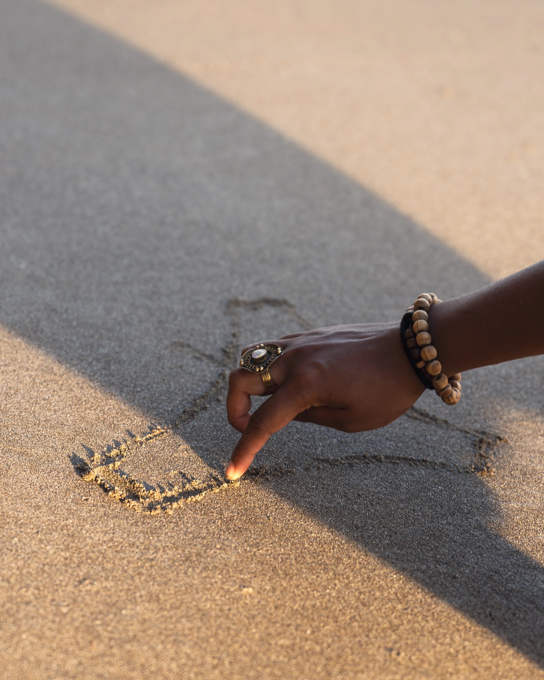 Hand sketching a Kiseau organic underwear in the sand on a beach
