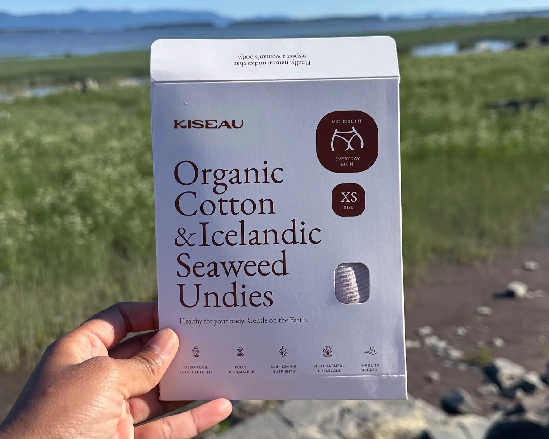 Kiseau Organic Cotton & Icelandic Seaweed Undies packaging held in front of a natural landscape.