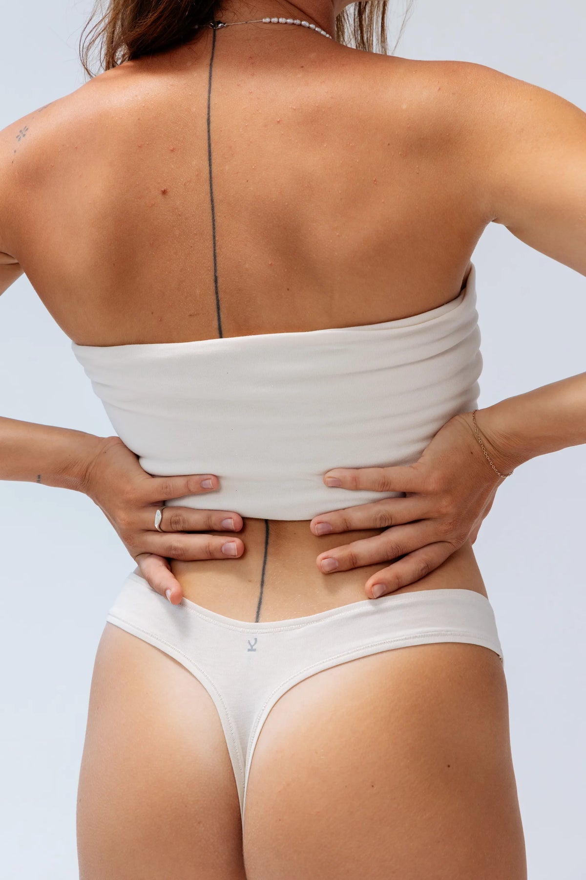 Kiseau Natural Undyed Classic Thong back detail with Kiseau logo tag — seaweed-infused organic cotton underwear