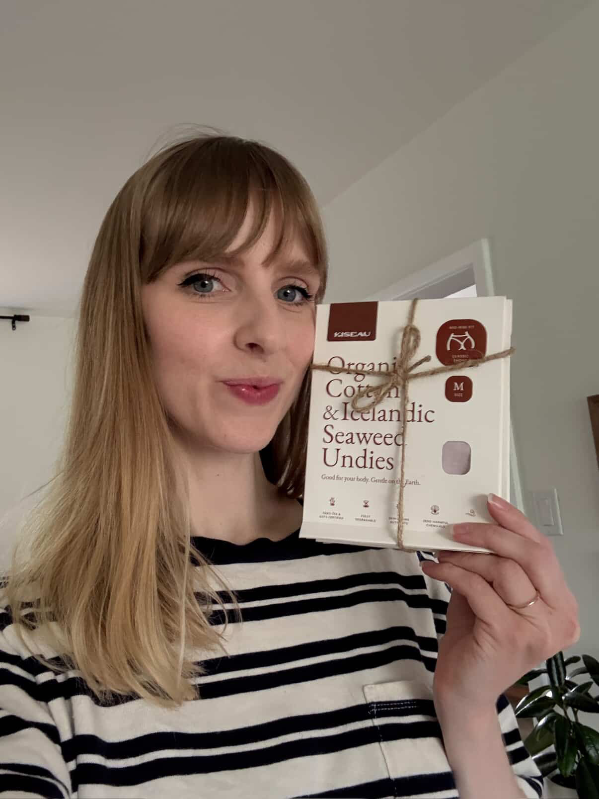 Customer posing with Kiseau Organic Cotton & Icelandic Seaweed Undies, highlighting eco-conscious packaging and natural fabric.